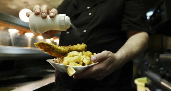 Manager Michael Upton adds salt to a customer's fish and chips at Mr Fish restaurant in north London May 22, 2012. Deep-fried fish in a crispy batter with fat golden chips is still as popular as ever with the British public, ranked alongside roast beef, Yorkshire pudding and chicken tikka masala as the nation's favourite dish. Picture taken May 22, 2012. REUTERS/Eddie Keogh (BRITAIN - Tags: FOOD SOCIETY) ATTENTION EDITORS: PICTURE 13 OF 29 FOR PACKAGE 'AS BRITISH AS FISH AND CHIPS'. SEARCH 'EDDIE FISH' TO FIND ALL IMAGES - RTR338CG