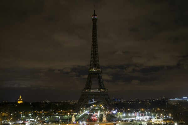 epa04684249 A view of the Eiffel Tower an instant with its lights switched off for the Earth Hour 2015 in Paris, France, 28 March 2015. 170 countries and 1200 monuments' lights are to be switched off at exactly 8.30pm local hours, taking part in the operation Earth Hour for its 2015 edition. Launched by the World Wide Foundation, the event is meant to highlight the importance to fight global warming.  EPA/ETIENNE LAURENT