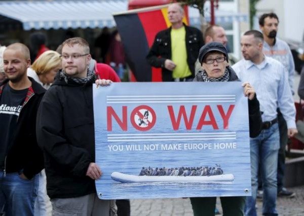 Supporters of the far-right National Democratic Party (NPD) hold a placard and a German flag during a march in Riesa, Germany, September 9, 2015. REUTERS/Fabrizio Bensch