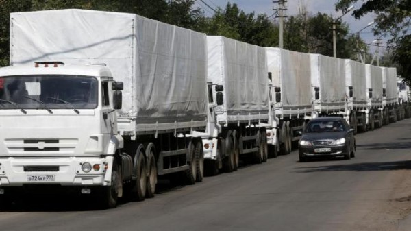 A car drives past trucks of a Russian convoy carrying humanitarian aid for Ukraine near a Russia-Ukraine border crossing point in Rostov Region, August 21, 2014. REUTERS/Alexander Demianchuk